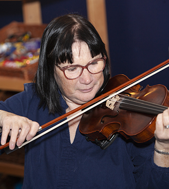 Adult playing in fiddle workshop