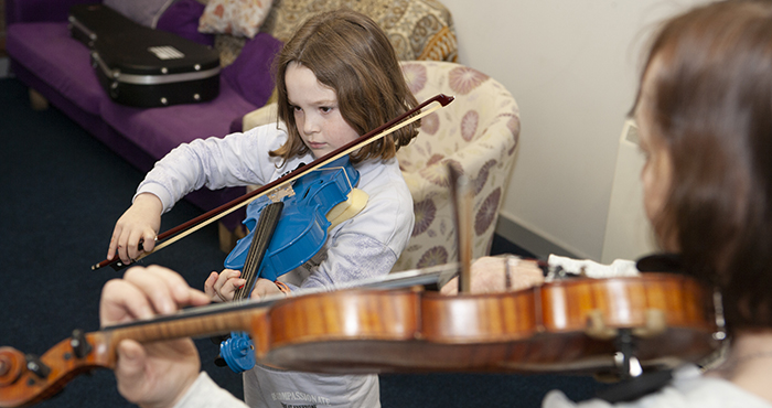 child playing fissle with tutor help