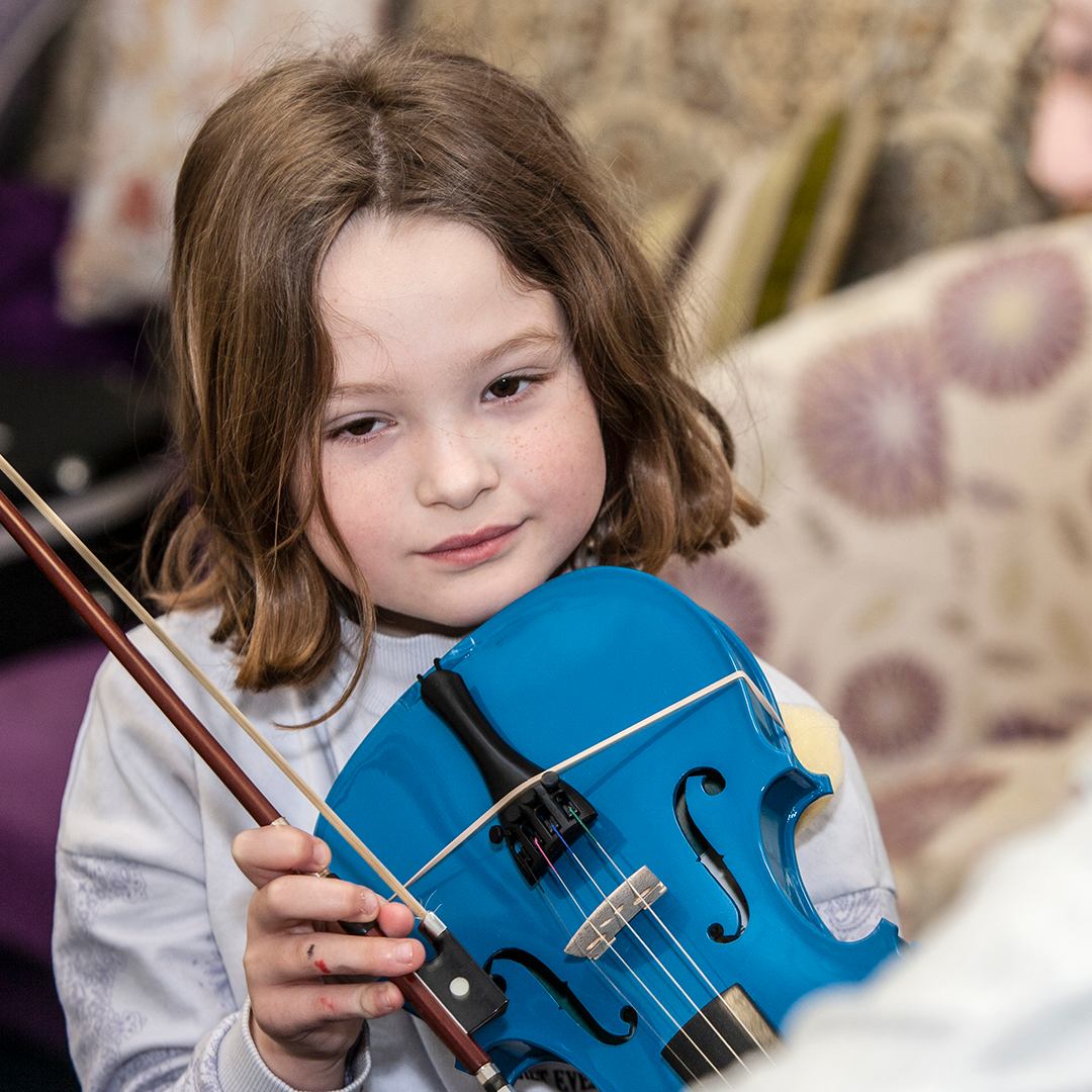 Child playing blue fiddle