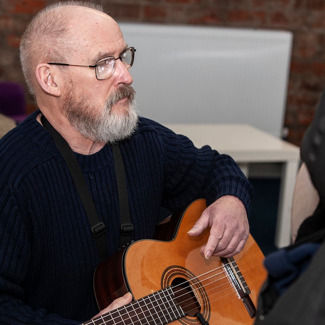 Adult playing acoustic guitar